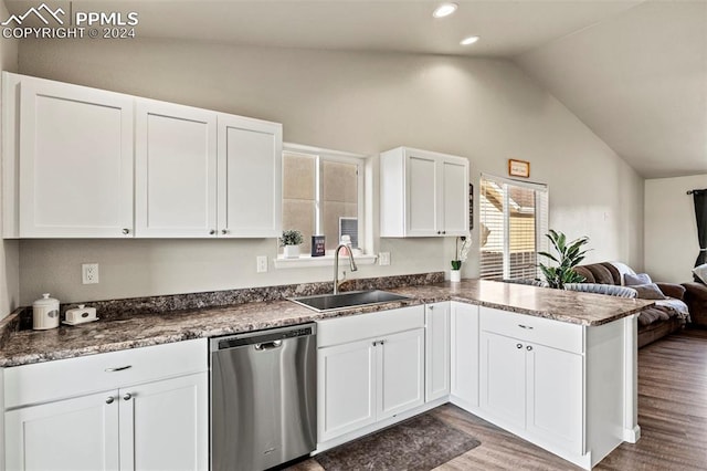 kitchen featuring lofted ceiling, stainless steel dishwasher, white cabinets, hardwood / wood-style flooring, and sink