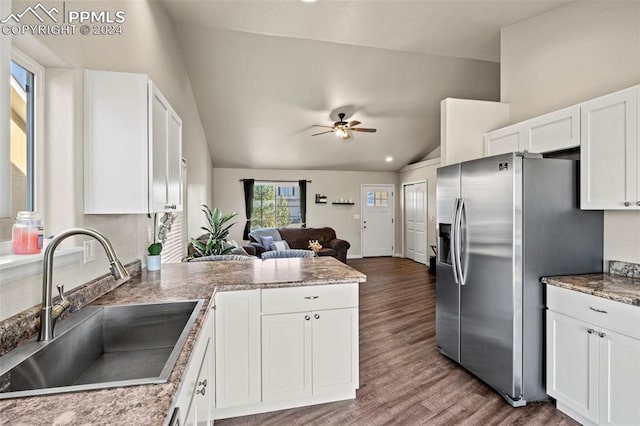 kitchen with wood-type flooring, white cabinets, stainless steel refrigerator with ice dispenser, and lofted ceiling