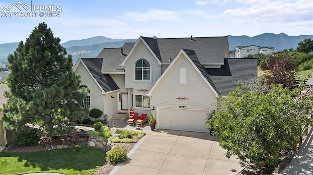 view of front of house featuring a mountain view, a garage, and a front lawn