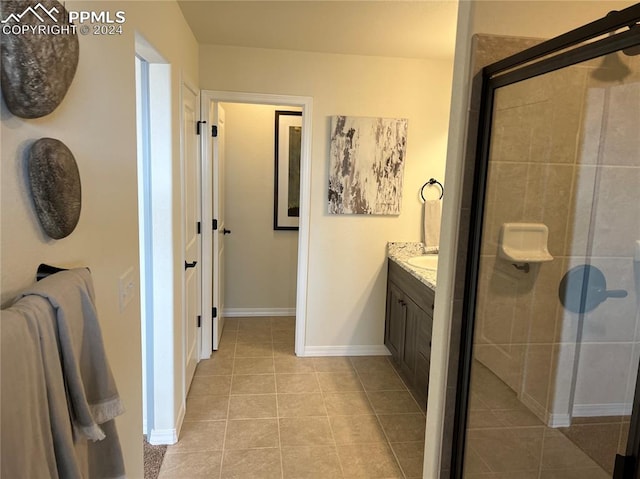 bathroom with a shower with door, tile patterned floors, and vanity