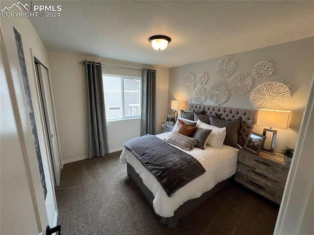 bedroom featuring dark carpet and a textured ceiling