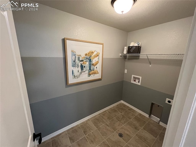 laundry room with washer hookup, a textured ceiling, dark tile patterned floors, and electric dryer hookup