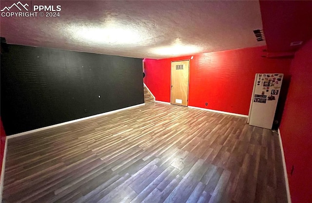 unfurnished room featuring a textured ceiling and hardwood / wood-style flooring