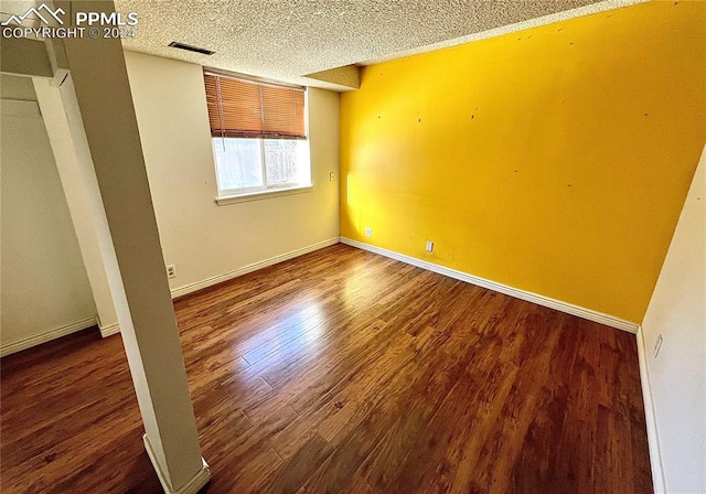 empty room featuring hardwood / wood-style flooring and a textured ceiling