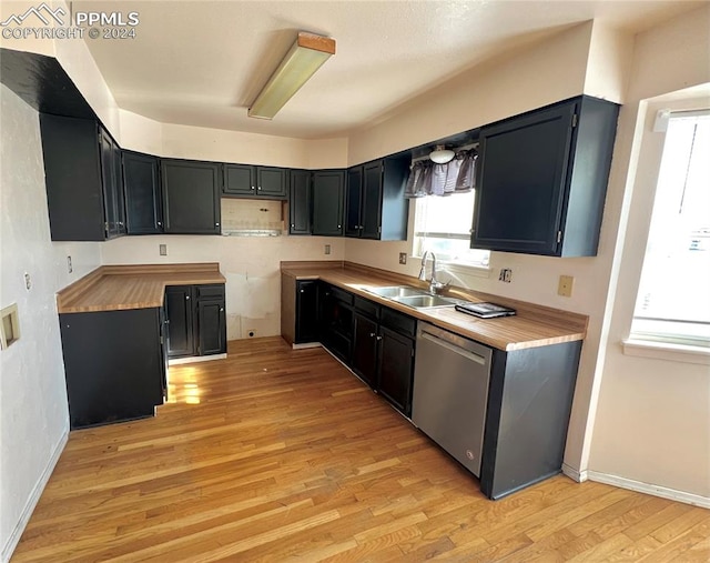 kitchen featuring stainless steel dishwasher, butcher block counters, sink, and light wood-type flooring