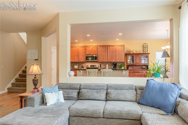 living room with a notable chandelier, a wealth of natural light, and hardwood / wood-style floors