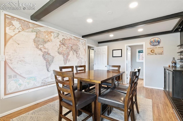 dining space featuring light hardwood / wood-style floors and beam ceiling