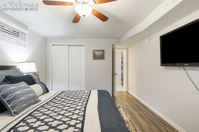 bedroom with hardwood / wood-style flooring, ceiling fan, and a closet