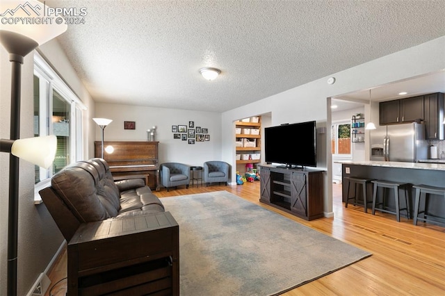 living room with light hardwood / wood-style floors and a textured ceiling