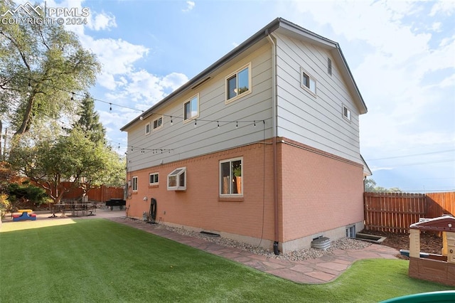 back of property featuring a patio and a lawn