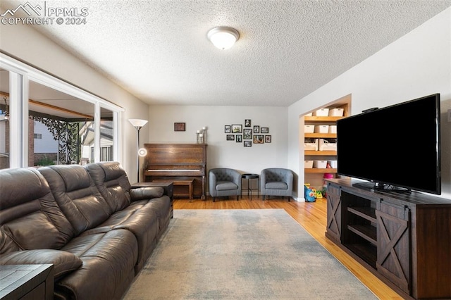 living room with light wood-type flooring and a textured ceiling