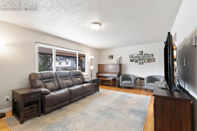 living room featuring light hardwood / wood-style floors and a textured ceiling