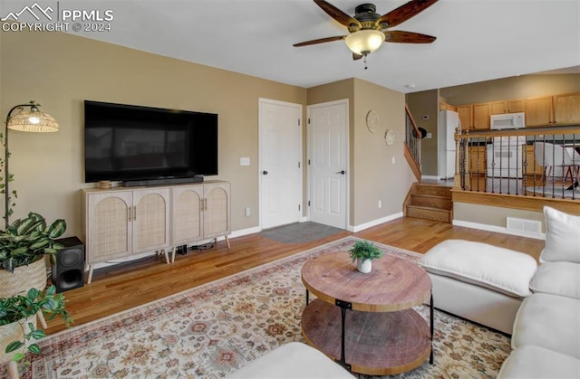 living room featuring wood-type flooring and ceiling fan