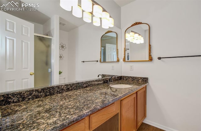 bathroom featuring a shower with shower door, vanity, and hardwood / wood-style flooring