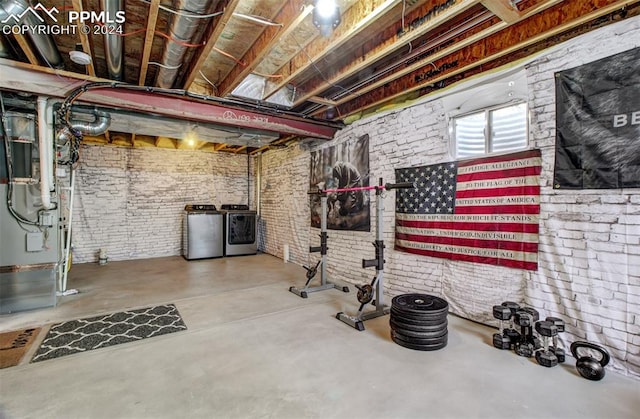 basement featuring separate washer and dryer and brick wall