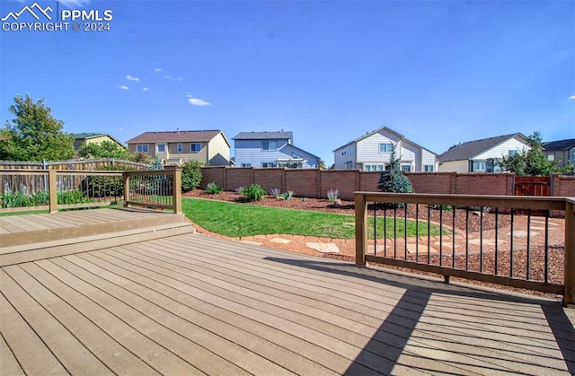 wooden deck featuring a lawn