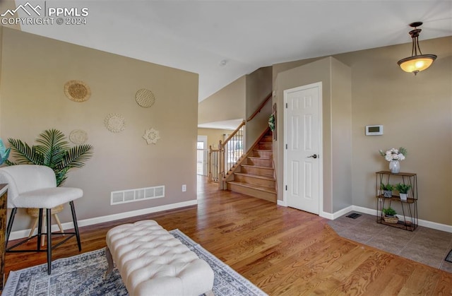 entrance foyer with hardwood / wood-style flooring and lofted ceiling