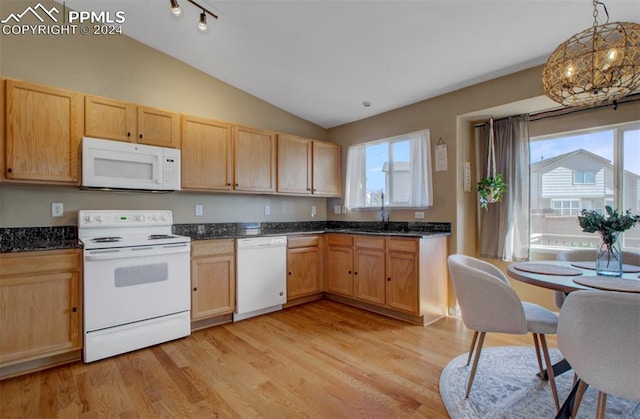 kitchen with lofted ceiling, white appliances, decorative light fixtures, and a healthy amount of sunlight