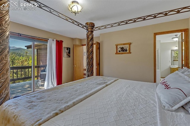 bedroom with access to exterior, a textured ceiling, and ensuite bath