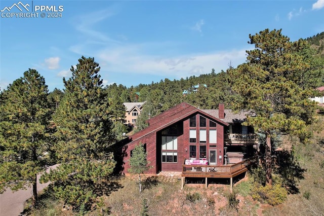 rear view of property featuring a wooden deck