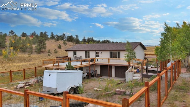 back of property featuring a garage and a deck