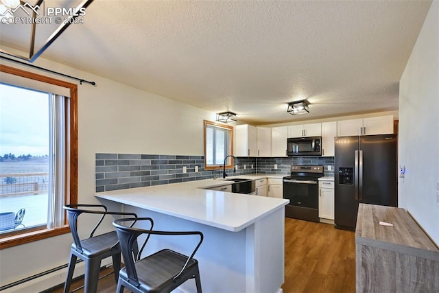 kitchen featuring appliances with stainless steel finishes, kitchen peninsula, sink, and white cabinets