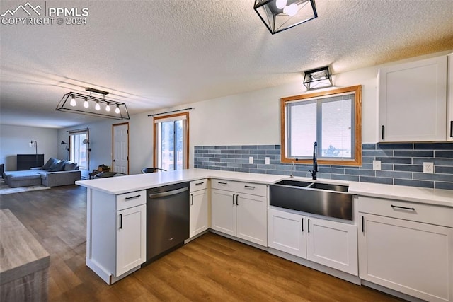 kitchen with dishwasher, kitchen peninsula, white cabinets, and sink