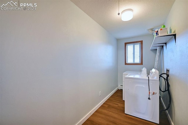 washroom featuring a textured ceiling, dark hardwood / wood-style floors, and independent washer and dryer