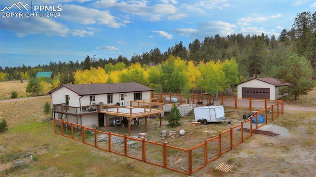 exterior space with a garage, a wooden deck, and an outdoor structure