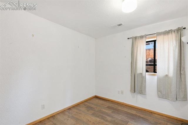 unfurnished room with hardwood / wood-style floors