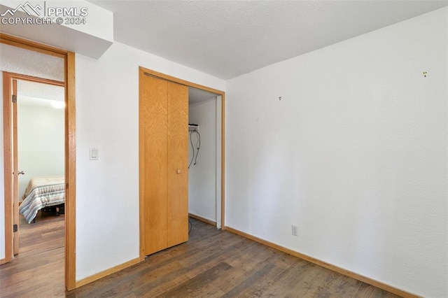 unfurnished bedroom with dark hardwood / wood-style floors