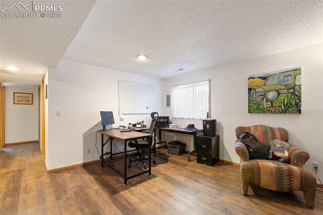 office featuring wood-type flooring and a textured ceiling