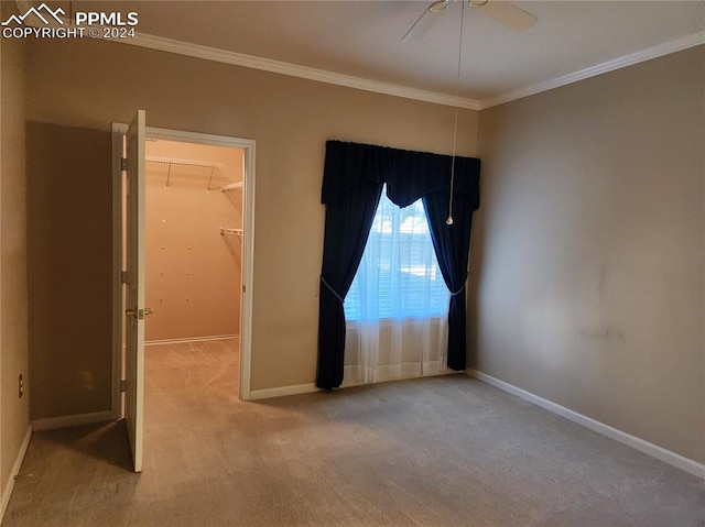 unfurnished room with ornamental molding, light colored carpet, and ceiling fan