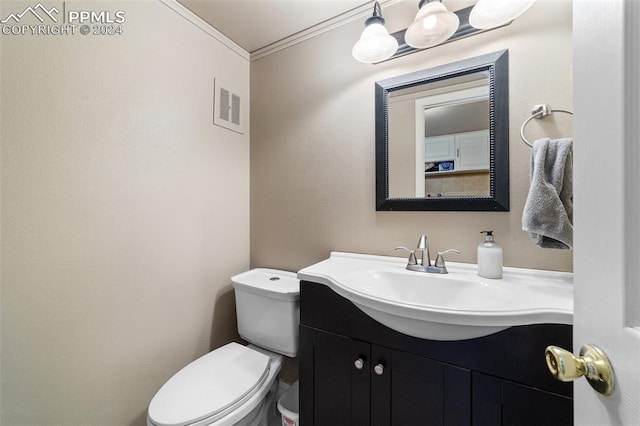 bathroom featuring crown molding, toilet, and vanity