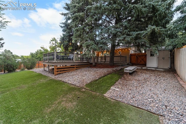 view of yard with a wooden deck and a shed