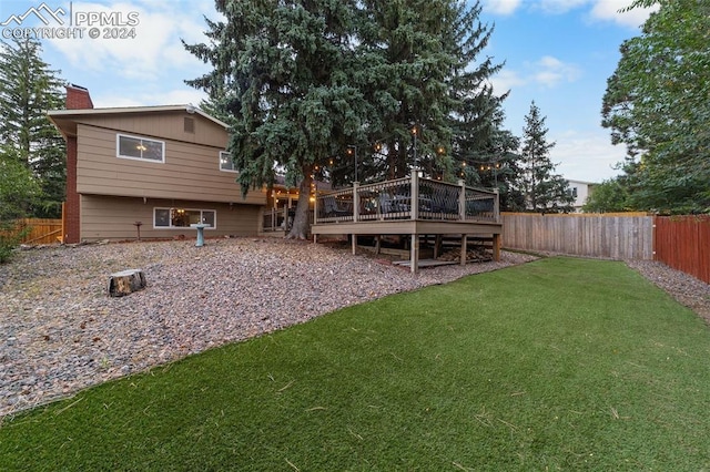 back of property featuring a wooden deck and a yard