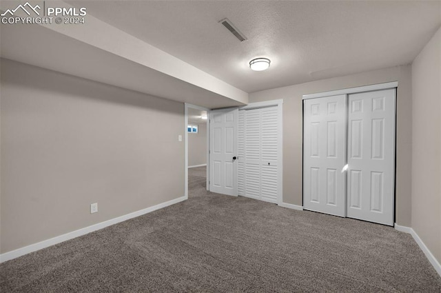 basement featuring carpet floors and a textured ceiling