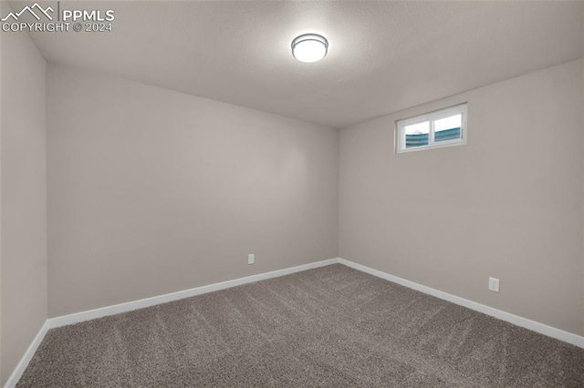 carpeted spare room with a textured ceiling