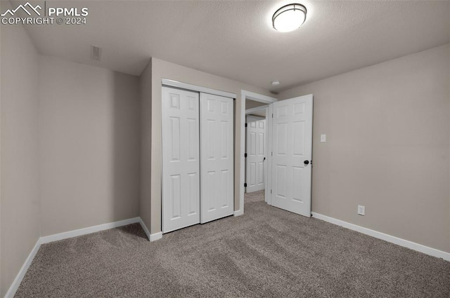 unfurnished bedroom with a closet, carpet flooring, and a textured ceiling