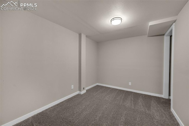 carpeted empty room featuring a textured ceiling