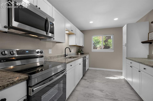 kitchen featuring appliances with stainless steel finishes, stone counters, sink, and white cabinets