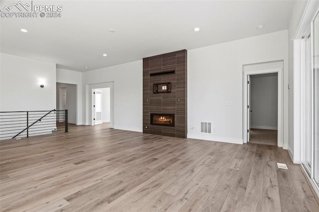 unfurnished living room with a fireplace and light wood-type flooring