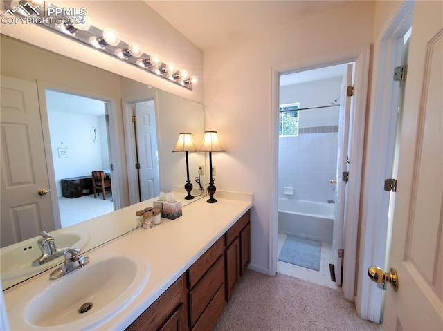 bathroom with tiled shower / bath and vanity