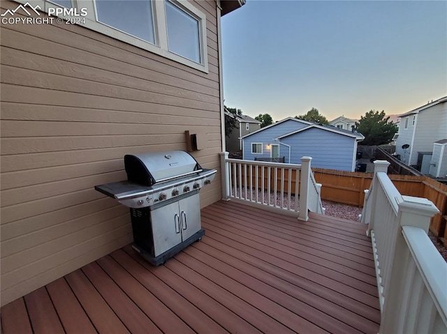 deck at dusk featuring area for grilling