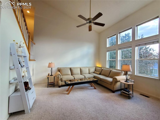 carpeted living room with high vaulted ceiling and ceiling fan