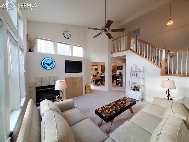 living room with light carpet, high vaulted ceiling, ceiling fan, and a tile fireplace