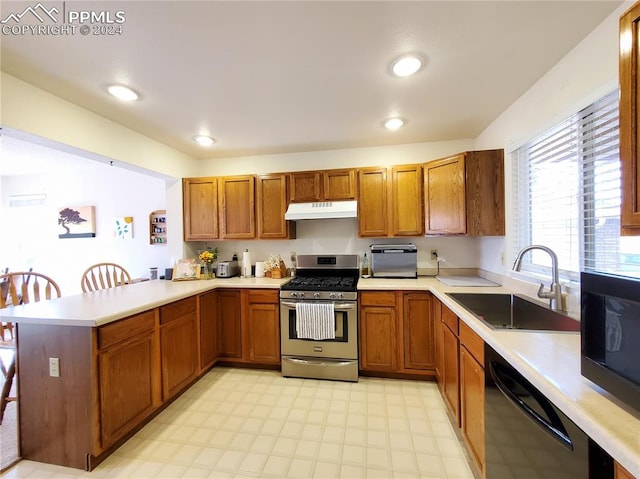 kitchen with appliances with stainless steel finishes, kitchen peninsula, and sink