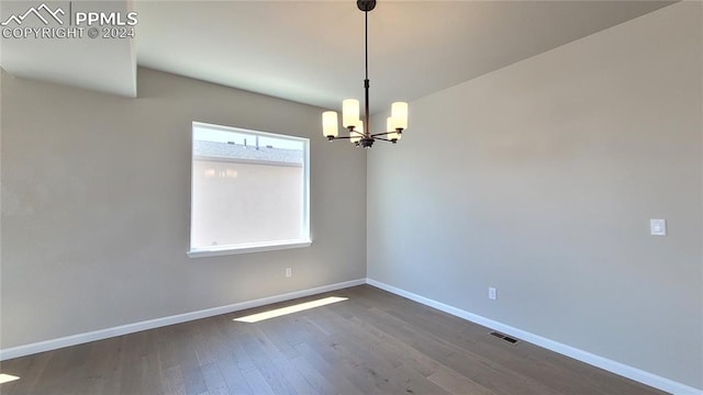 unfurnished room with a chandelier and hardwood / wood-style floors