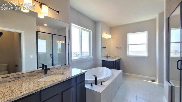 full bathroom with tile patterned flooring, plenty of natural light, separate shower and tub, and vanity