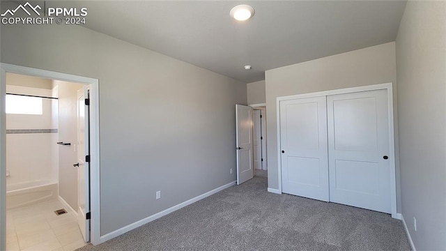 unfurnished bedroom with a closet and carpet flooring